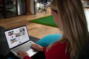 remote werken — Woman using a laptop with video conference on screen